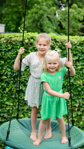 Julie met grote zus Emily op de schommel